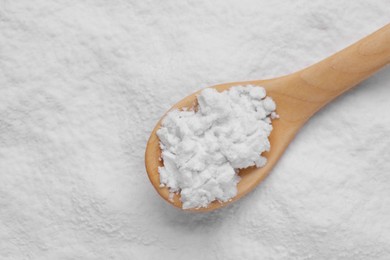 Photo of Heap of natural starch and wooden spoon, top view