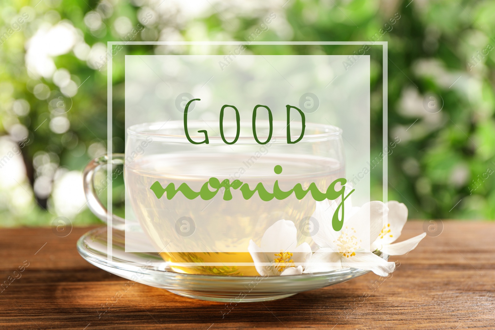 Image of Good morning. Glass cup of aromatic jasmine tea and fresh flowers on wooden table