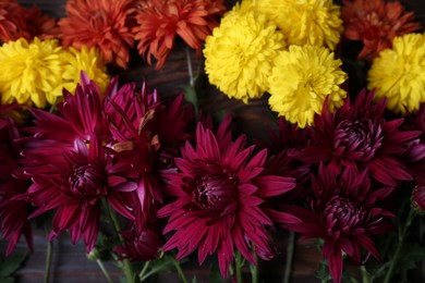 Photo of Flat lay composition with different beautiful chrysanthemum flowers on wooden table