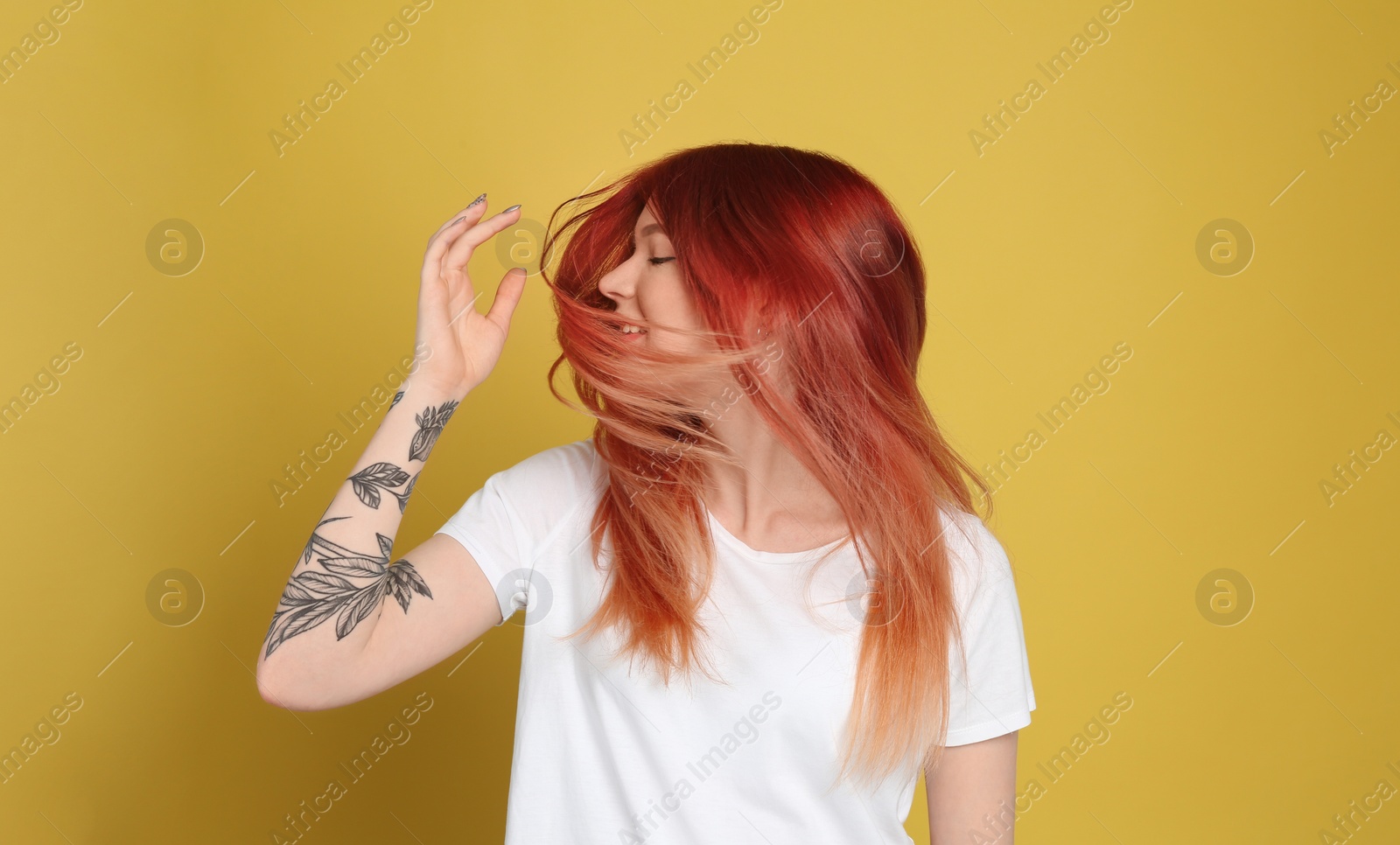 Photo of Young woman with bright dyed hair on yellow background