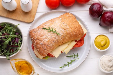 Photo of Delicious sandwich with tasty filling and ingredients on white wooden table, flat lay