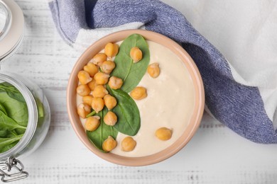 Photo of Tasty chickpea soup in bowl on white wooden table, flat lay