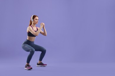 Photo of Woman in sportswear doing exercises on violet background, space for text