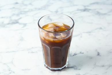 Glass with cold brew coffee on light background