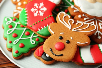 Different tasty Christmas cookies on white plate, closeup