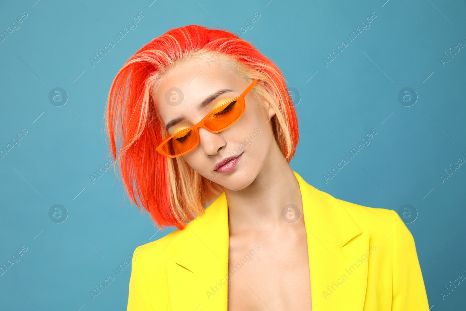 Photo of Beautiful young woman with bright dyed hair on turquoise background
