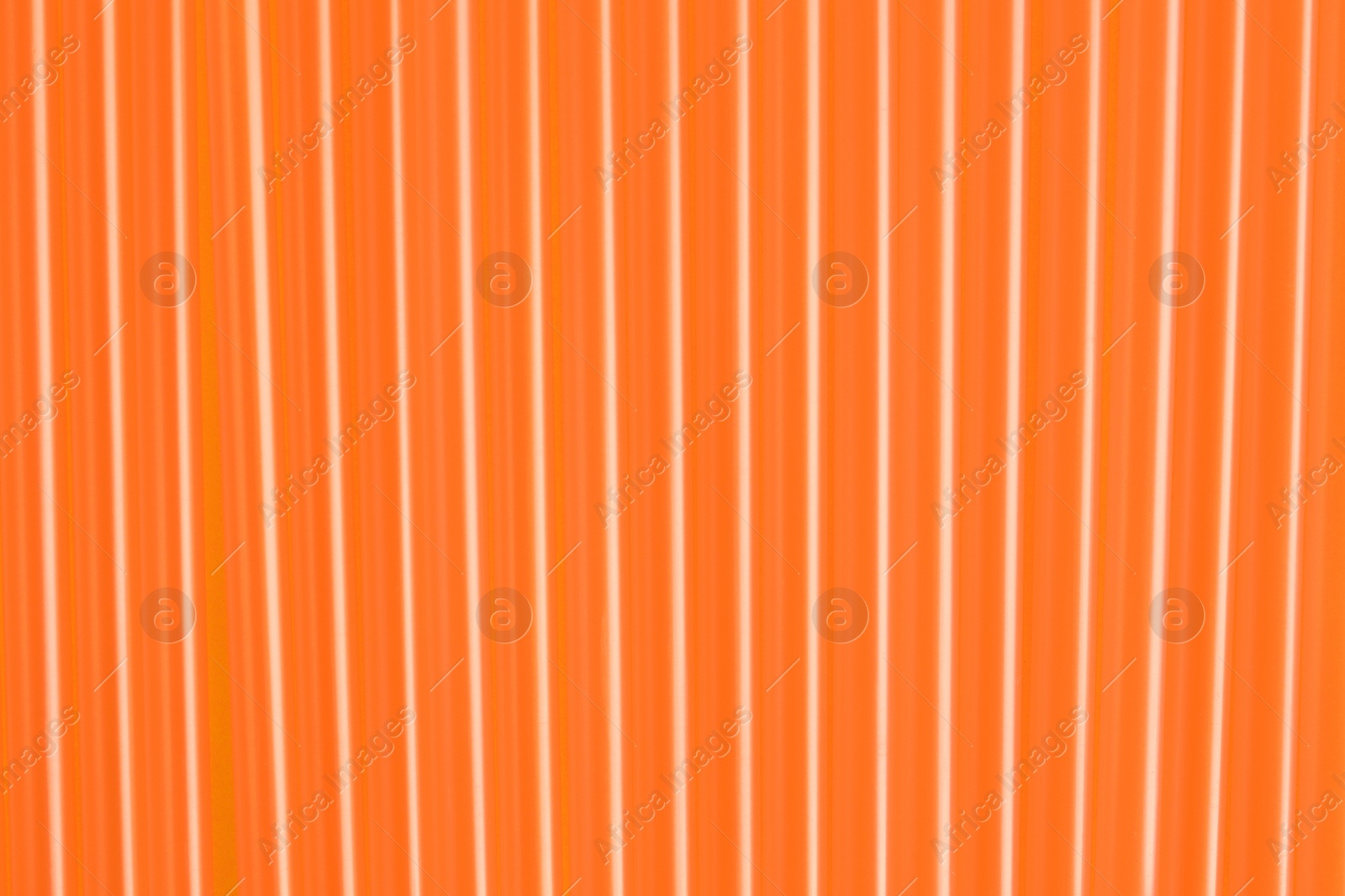 Photo of Many orange plastic drinking straws as background, closeup