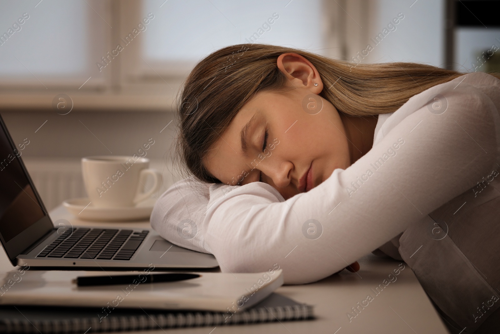 Photo of Tired young woman sleeping at workplace in office