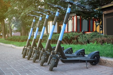 Many modern electric scooters parked on city street. Rental service