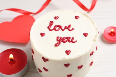 Bento cake with text Love You, candles and paper heart on white wooden table, closeup. St. Valentine's day surprise