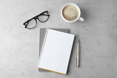 Photo of Flat lay composition with office stationery and cup of coffee on light stone background. Space for design