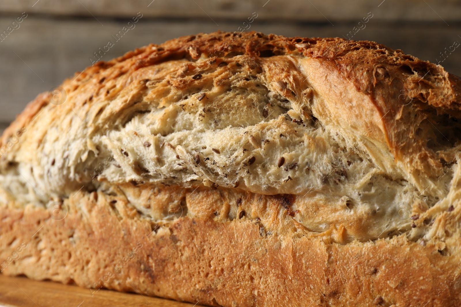 Photo of Freshly baked sourdough bread on wooden table, closeup