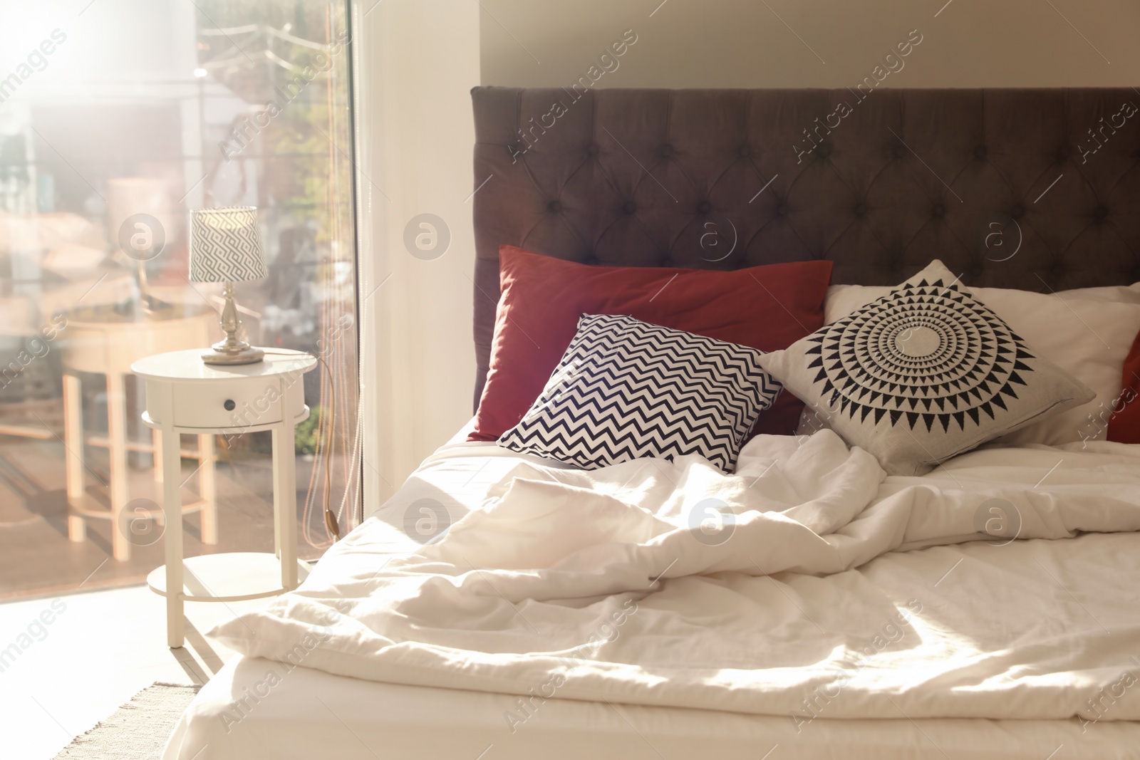 Photo of Different pillows on bed in room. Idea for interior decor