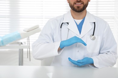 Photo of Young doctor holding something at table in clinic, closeup