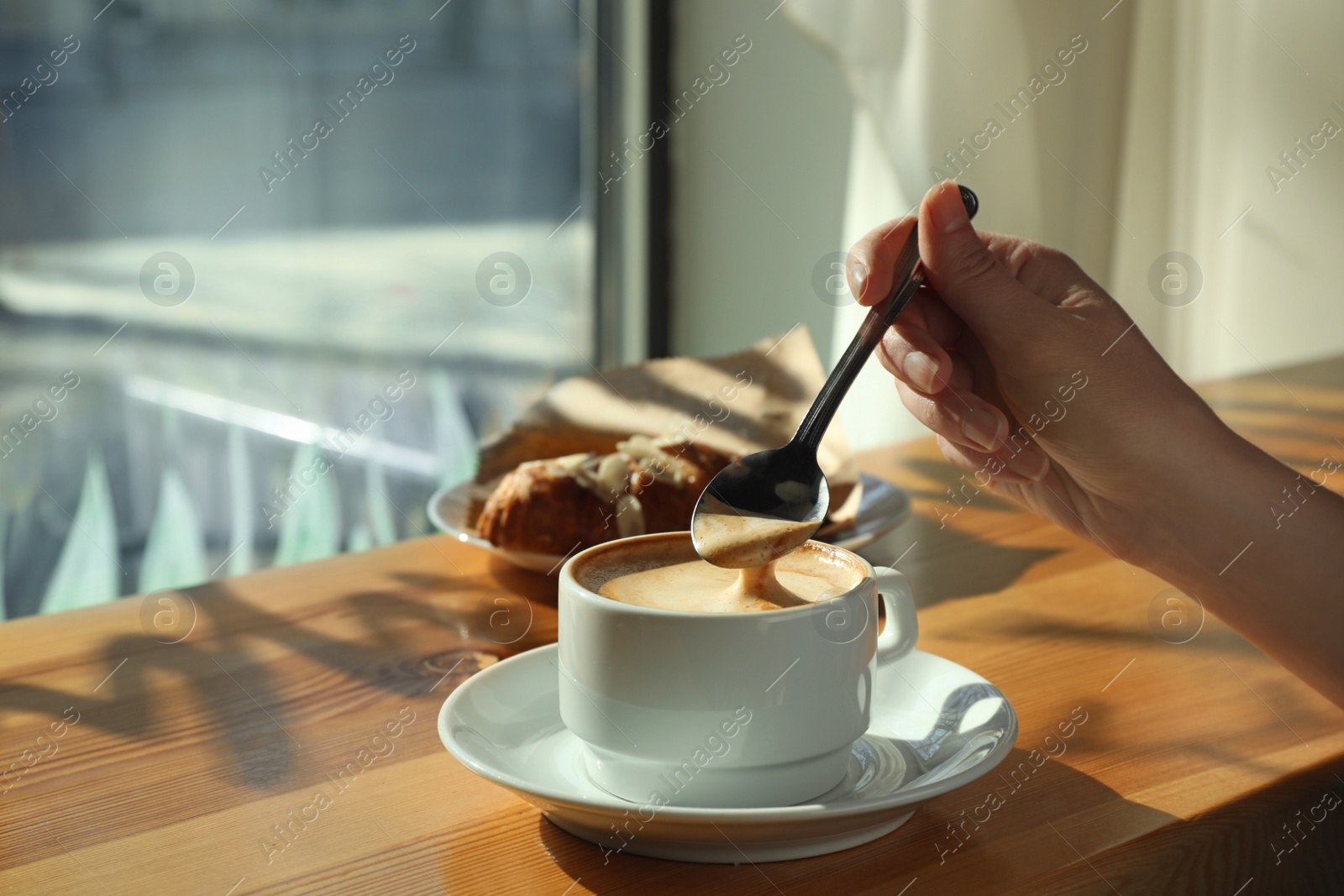 Photo of Woman with cup of fresh aromatic coffee at table in cafe