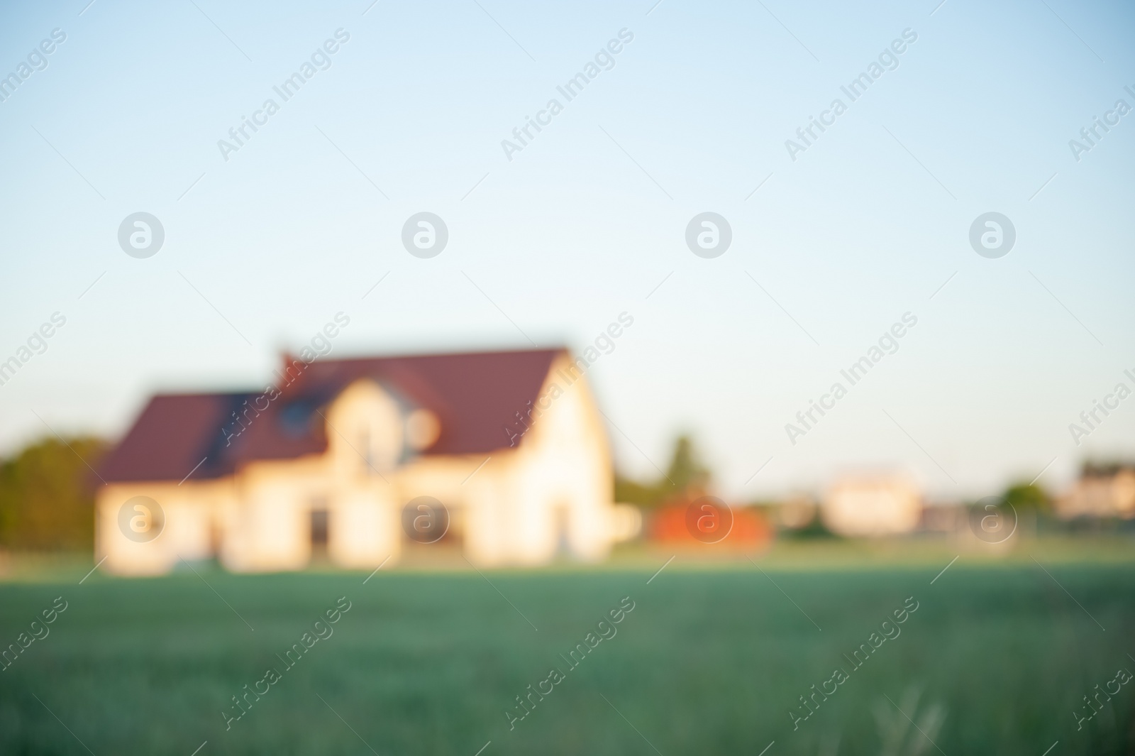 Photo of Blurred view of beautiful house with green lawn on sunny day