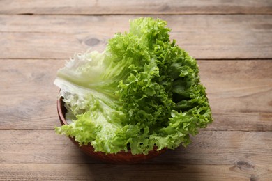 Photo of Fresh lettuce on wooden table. Salad greens