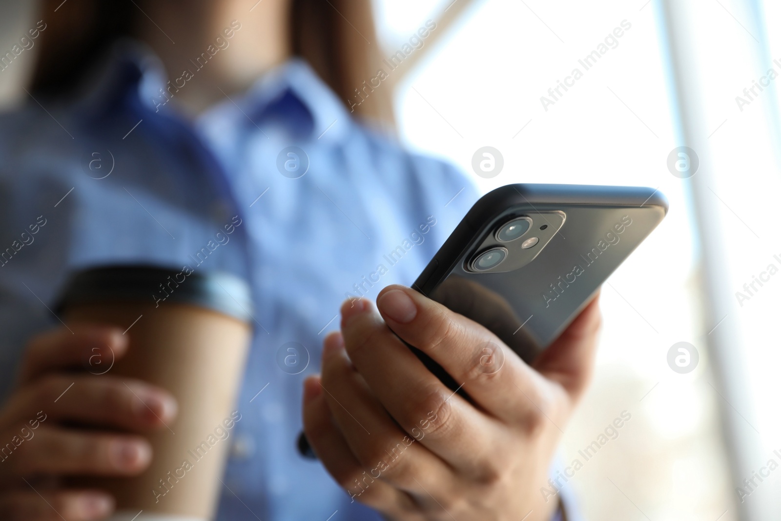 Photo of MYKOLAIV, UKRAINE - MARCH 16, 2020: Woman holding iPhone 11 Black indoors, closeup