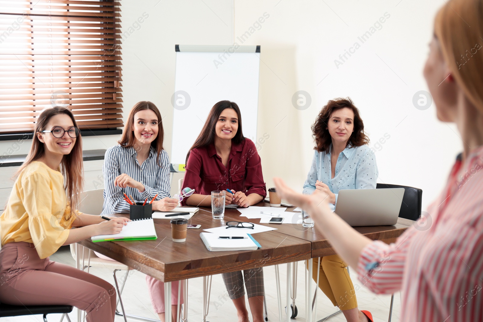 Photo of Female professional business trainer working with ladies in office. Women power concept