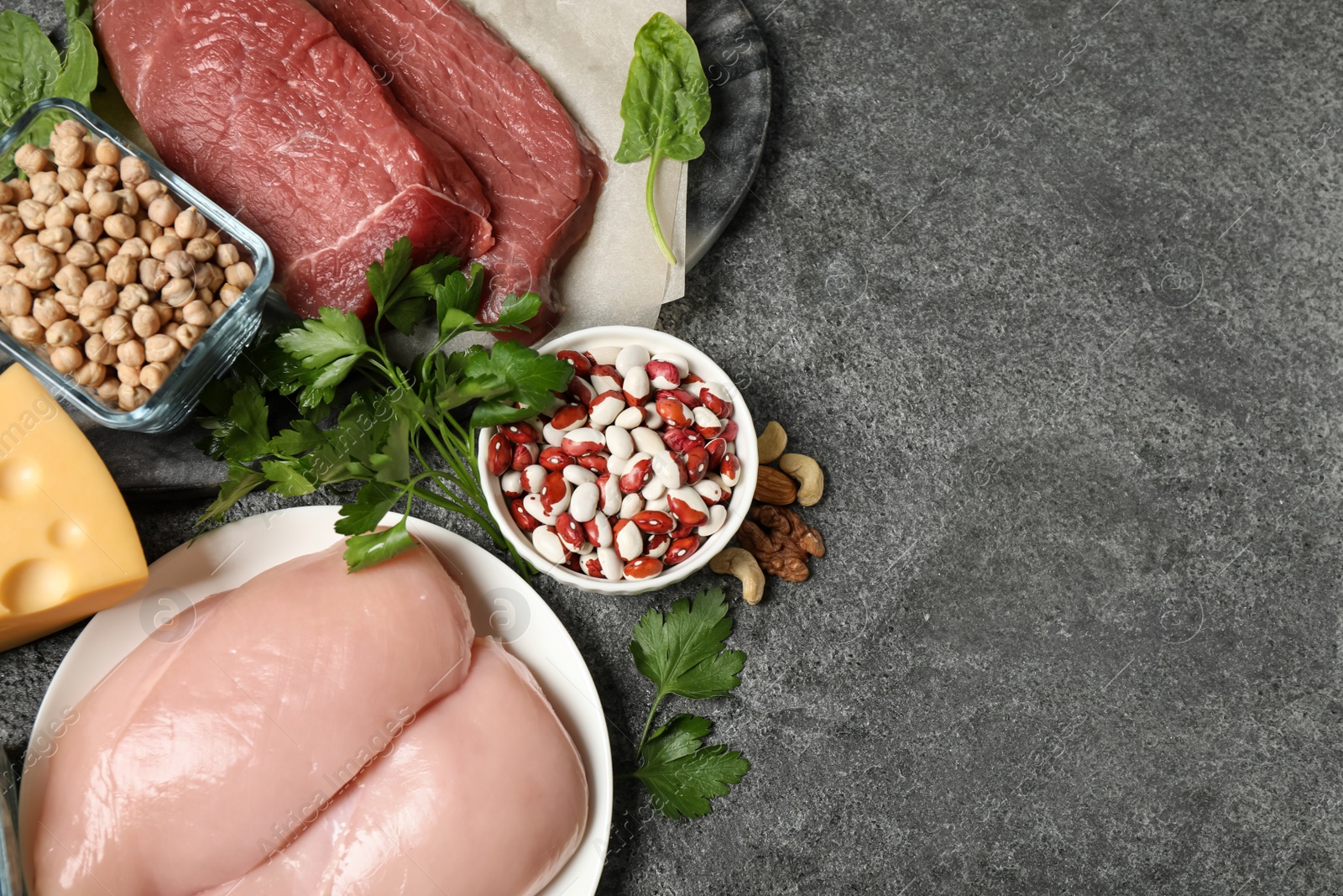 Photo of Products rich in protein on grey table, flat lay. Space for text