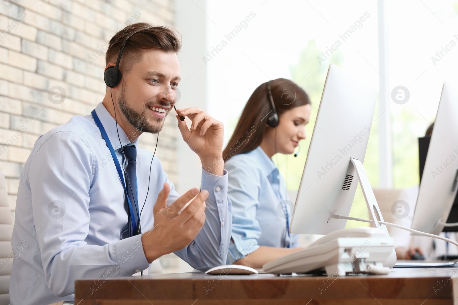 Photo of Technical support operators with headsets at workplace