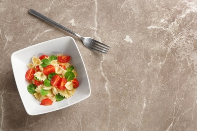 Bowl with delicious pasta primavera on grey background, top view