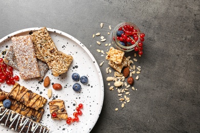 Photo of Plate with different grain cereal bars on table, top view. Healthy snack