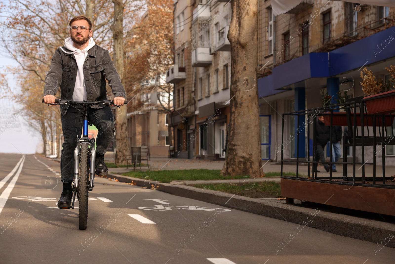 Photo of Handsome man riding bicycle on lane in city