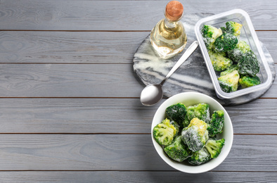 Photo of Flat lay composition with frozen broccoli on light grey wooden table, space for text. Vegetable preservation