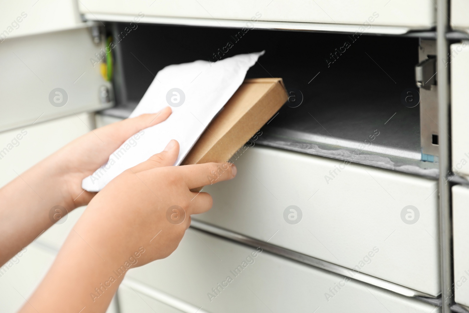 Photo of Woman taking packages out of parcel locker, closeup