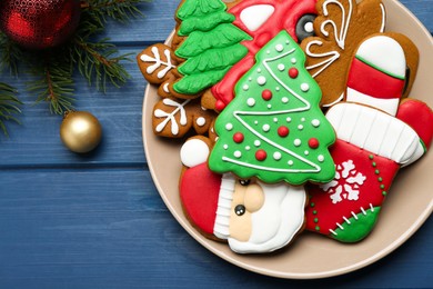 Photo of Different tasty Christmas cookies and decor on blue wooden table, flat lay