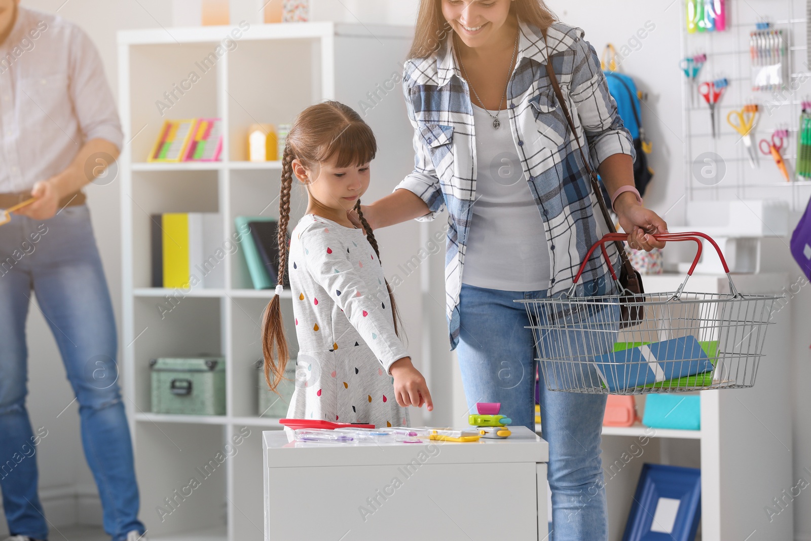 Photo of Little girl with mother choosing school stationery in store