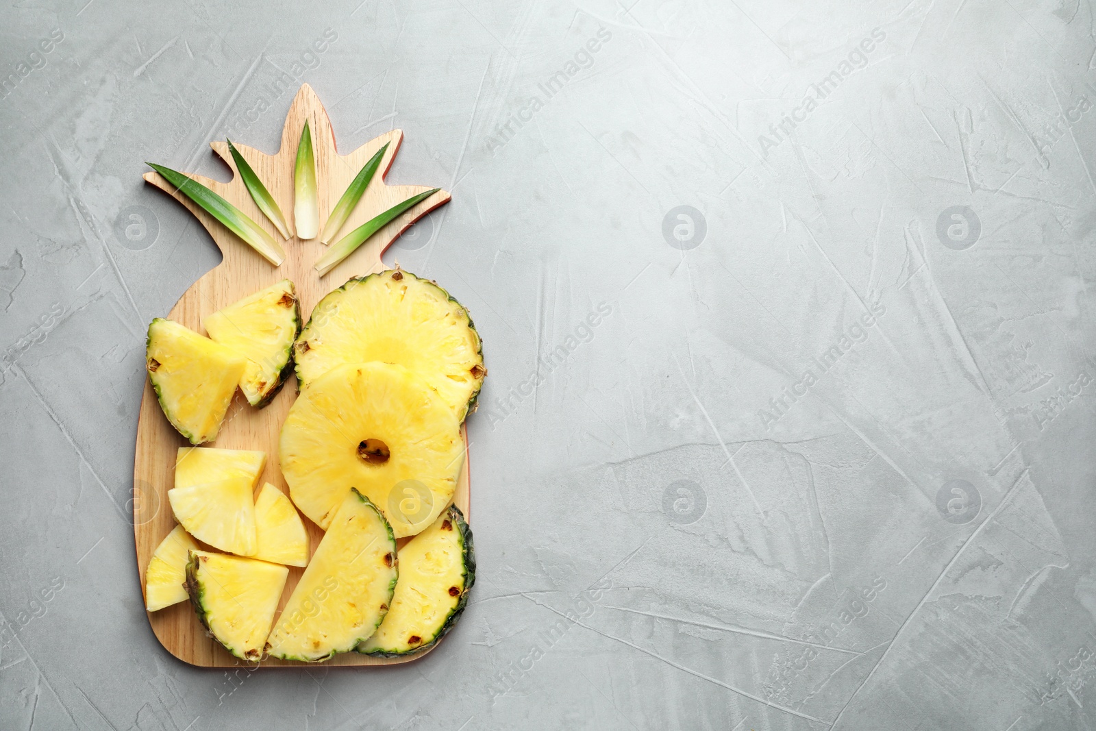 Photo of Flat lay composition with fresh sliced pineapple on gray background