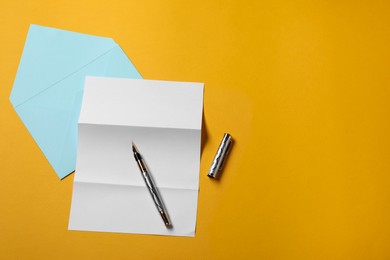 Photo of Blank sheet of paper, letter envelope and pen on orange background, top view. Space for text