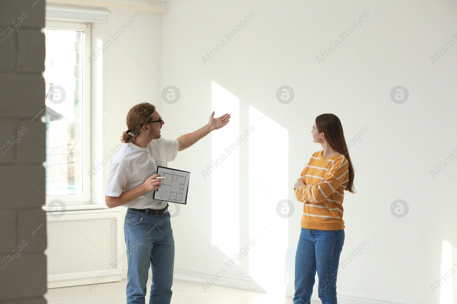 Photo of Professional interior designer consulting woman in empty apartment