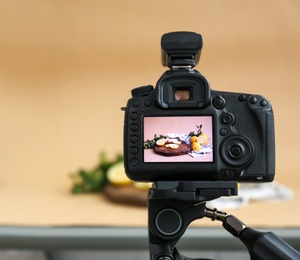 Professional camera with picture of cut lemons, mint and ginger on display in studio. Food photography