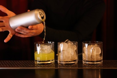 Photo of Bartender pouring energy drink into glass at counter in bar, closeup