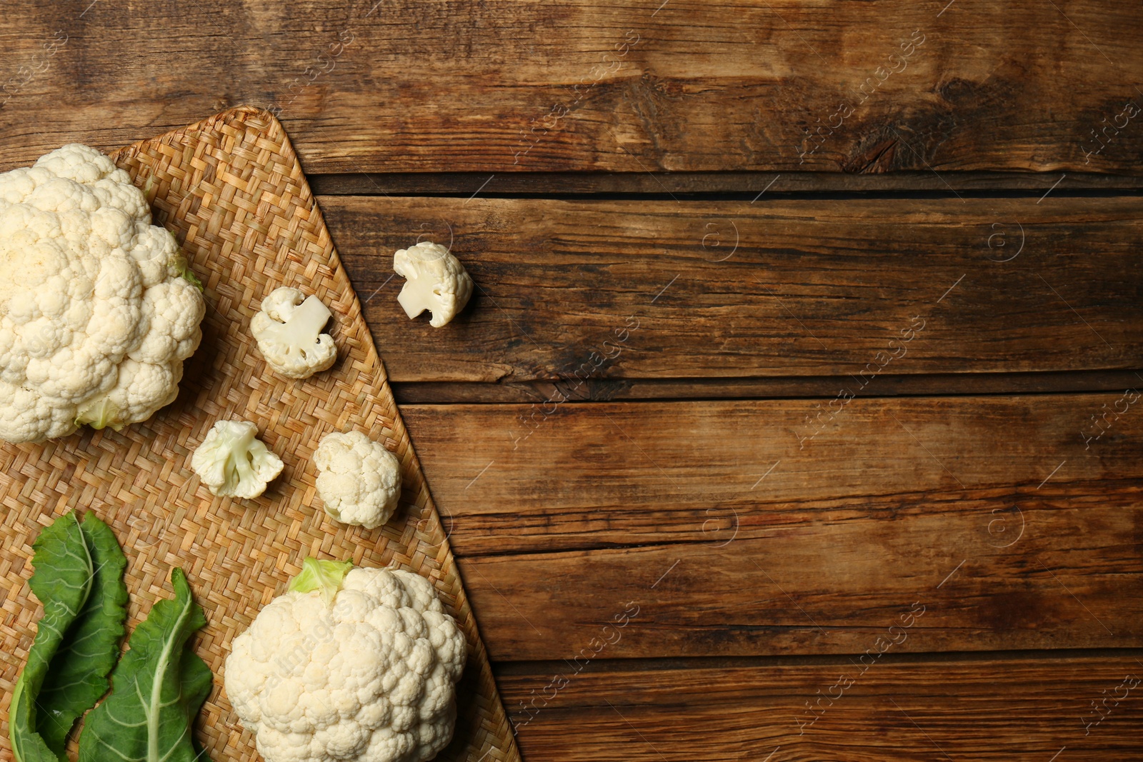 Photo of Fresh cauliflower on wooden table, top view. Space for text