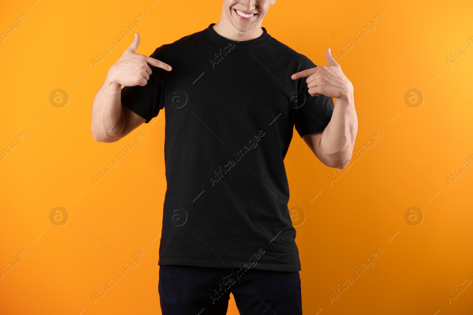 Photo of Young man in black t-shirt on color background. Mockup for design