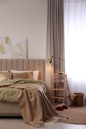 Photo of Comfortable bed with olive green linens in modern room interior