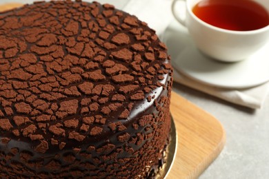 Photo of Delicious chocolate truffle cake and tea on light grey table