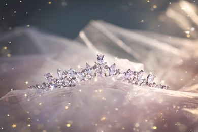 Beautiful tiara with diamonds on pink cloth, bokeh effect