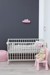 Photo of Stylish baby room interior with comfortable crib