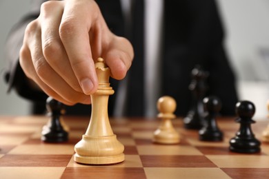 Photo of Man moving chess piece on board, closeup