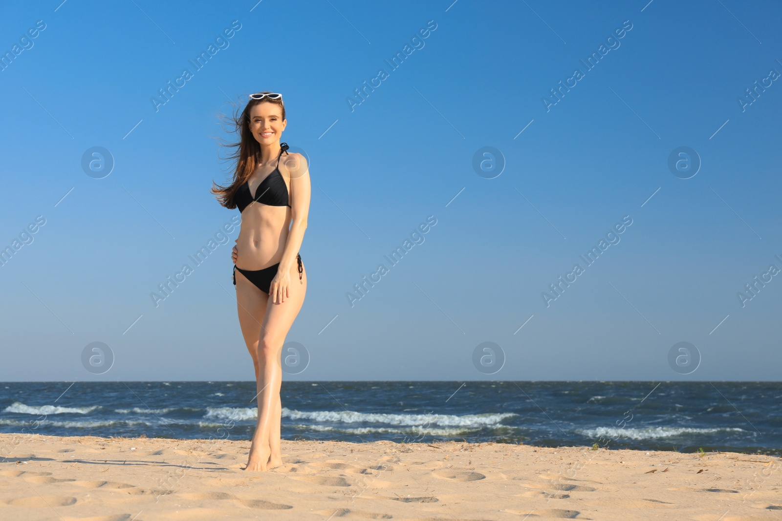 Photo of Beautiful woman in bikini on sea coast. Space for text