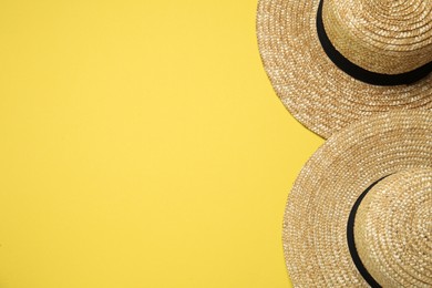 Straw hats on yellow background, top view with space for text. Sun protection