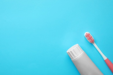 Photo of Blank tube of toothpaste and brush on color background, top view with space for text