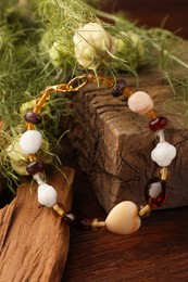 Photo of Stylish presentation of beautiful bracelet with gemstones on wooden table, closeup