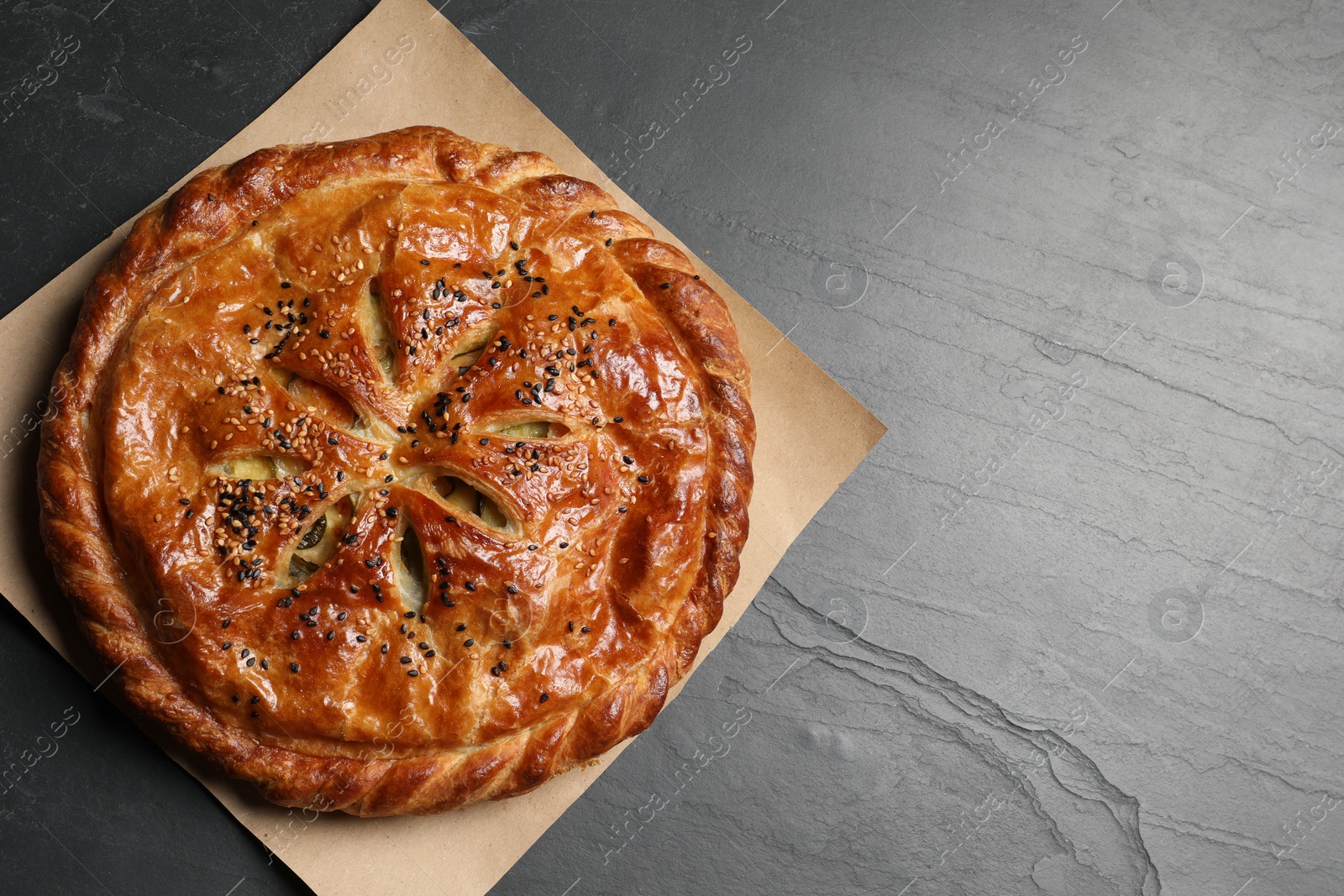 Photo of Tasty homemade pie with filling on grey table, top view. Space for text