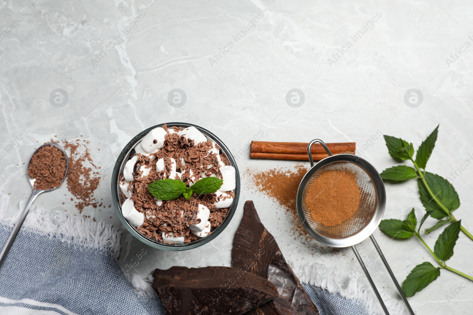 Photo of Glass of delicious hot chocolate with marshmallows and fresh mint on light grey marble table, flat lay. Space for text